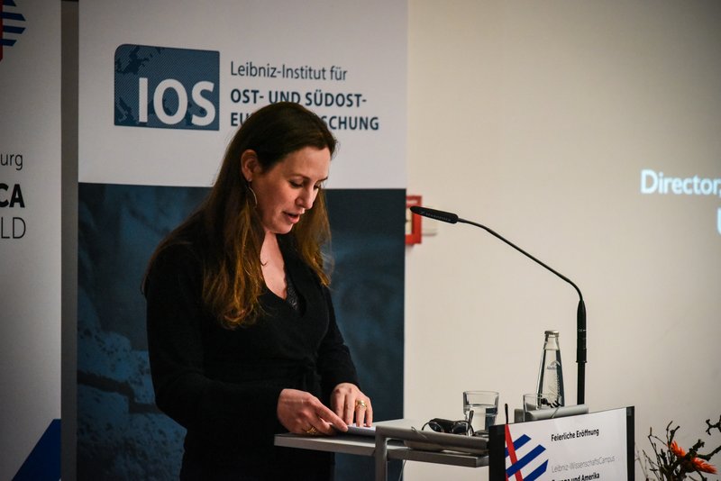 Geneviève Zubrzycki steht am Rednerpult. Während sie ihren Vortrag hält, blickt sie nach unten auf ihre Unterlage.
